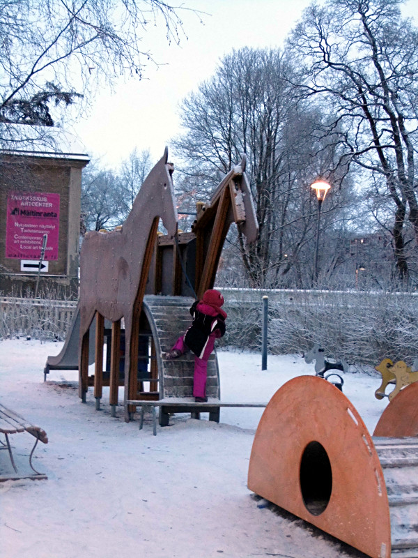 Julie grimpe sur le tobbogan cheval de Tallipiha, un exploit car c'est gelé.