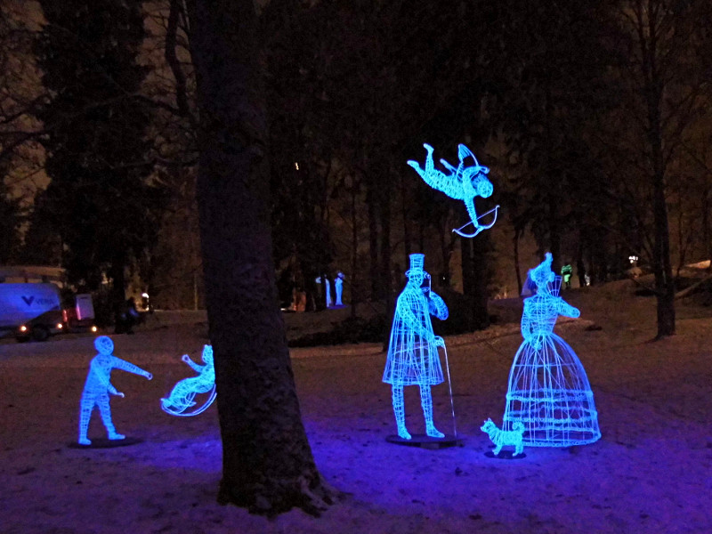 Les sculptures éclairées dans Nasinpuisto - cupidon face à un couple et petit enfant qui joue